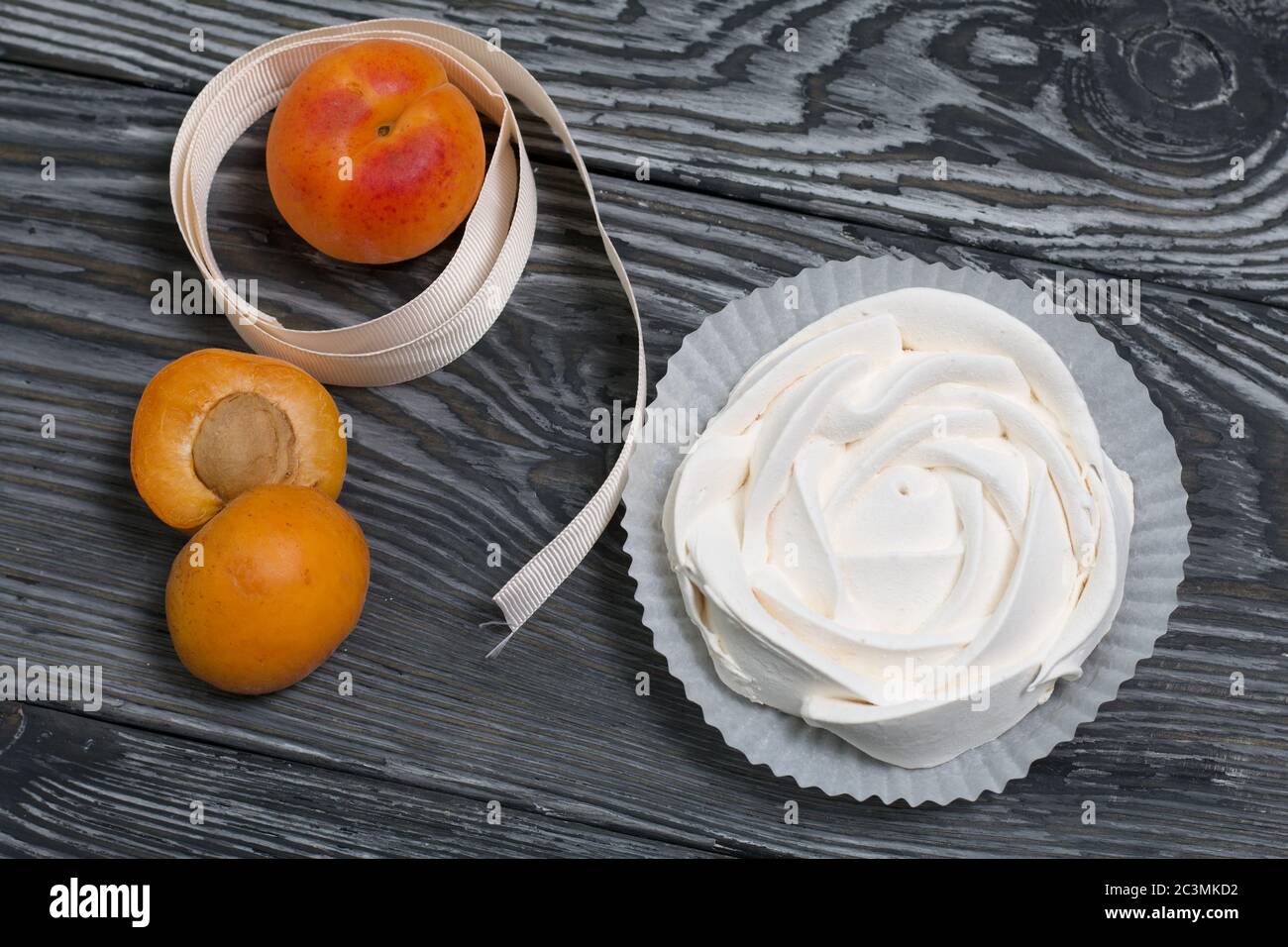 I marshmallows disposti su un vassoio nelle vicinanze sono albicocche mature. Foto Stock