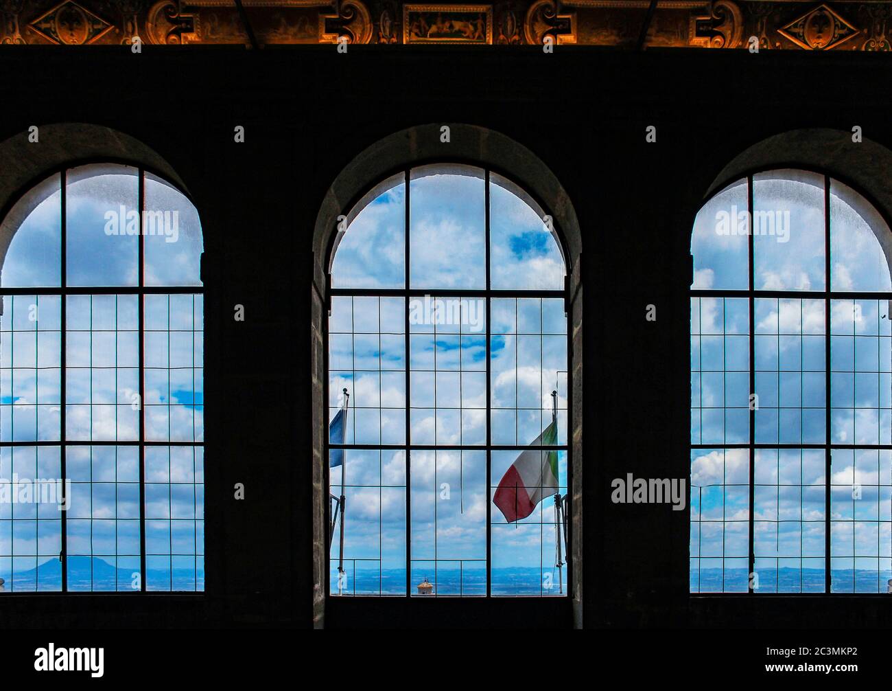 3 giugno 2016 - Caprarola, Viterbo, Lazio, Italy - Villa Farnese. Tre grandi finestre ad arco, che si affacciano sulla città, la bandiera italiana, le montagne a. Foto Stock