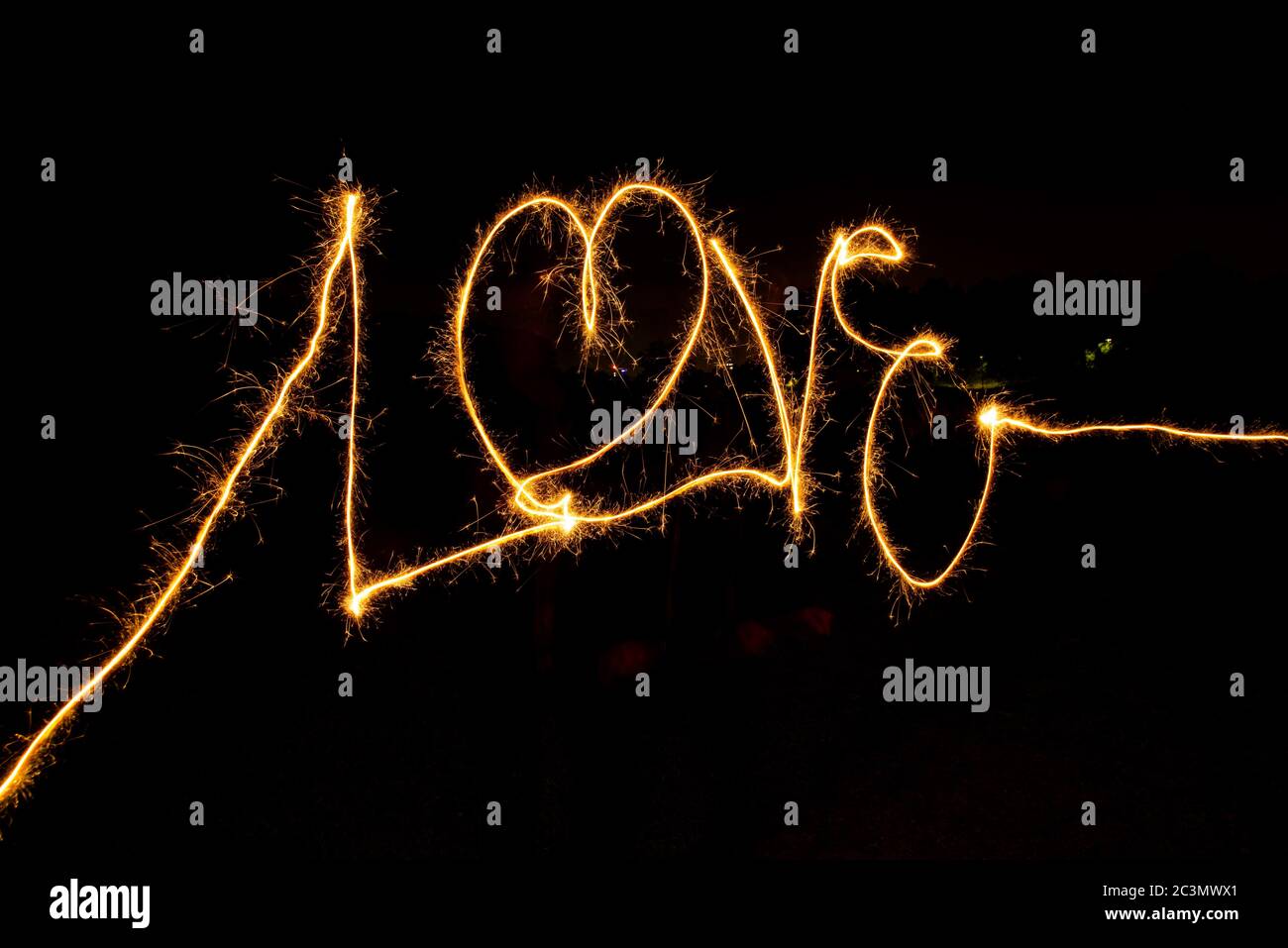 Sparkler pittura della parola 'amore' isolato su un nero sfondo Foto Stock