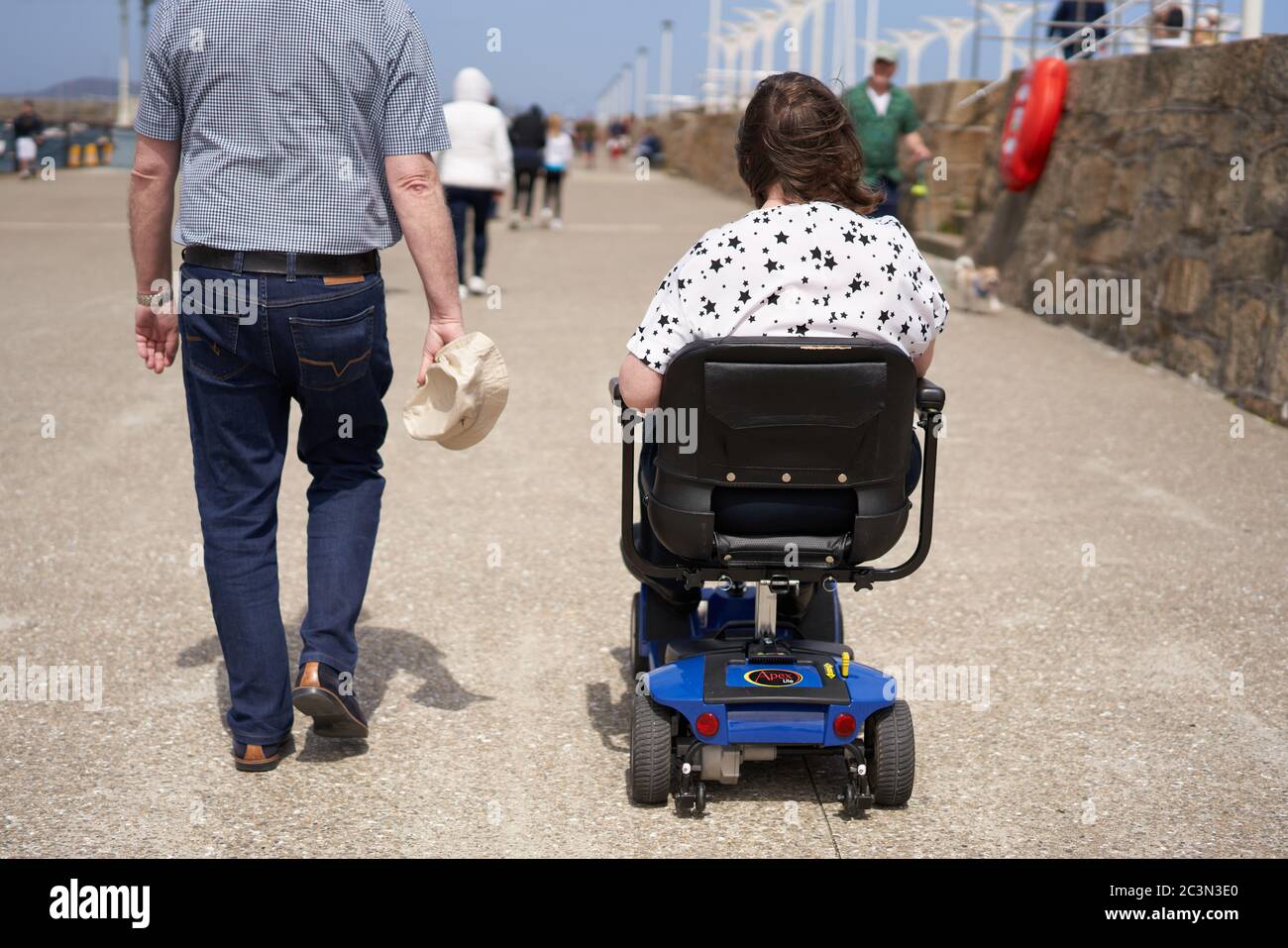 Le persone che si godono una passeggiata lungo il molo di Dun Laoghaire nella città di Dublino, Irlanda. Foto Stock