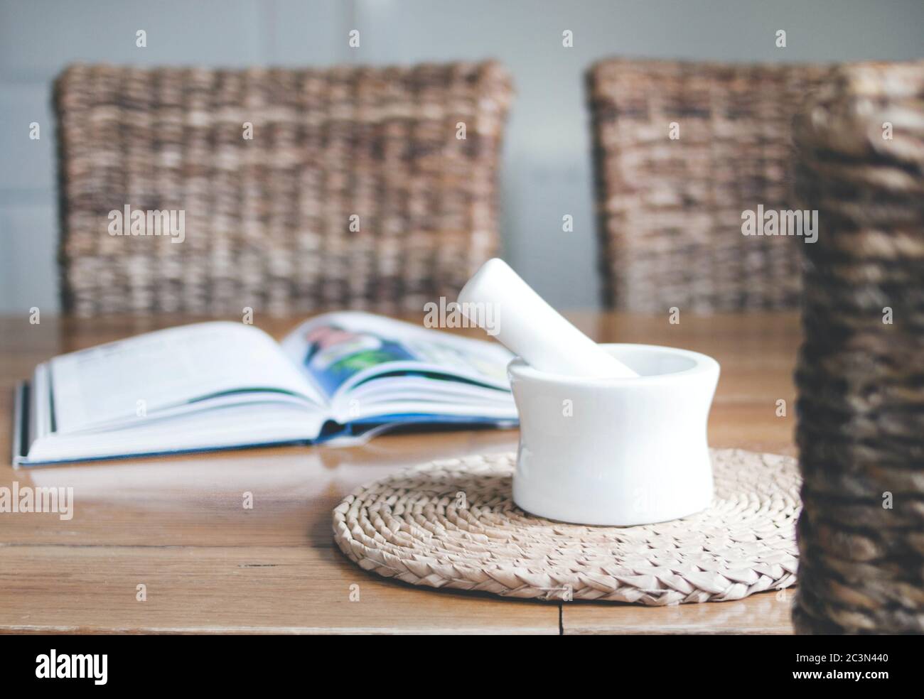 Primo piano di un macinacaffè bianco vicino a un aperto libro di ricette Foto Stock