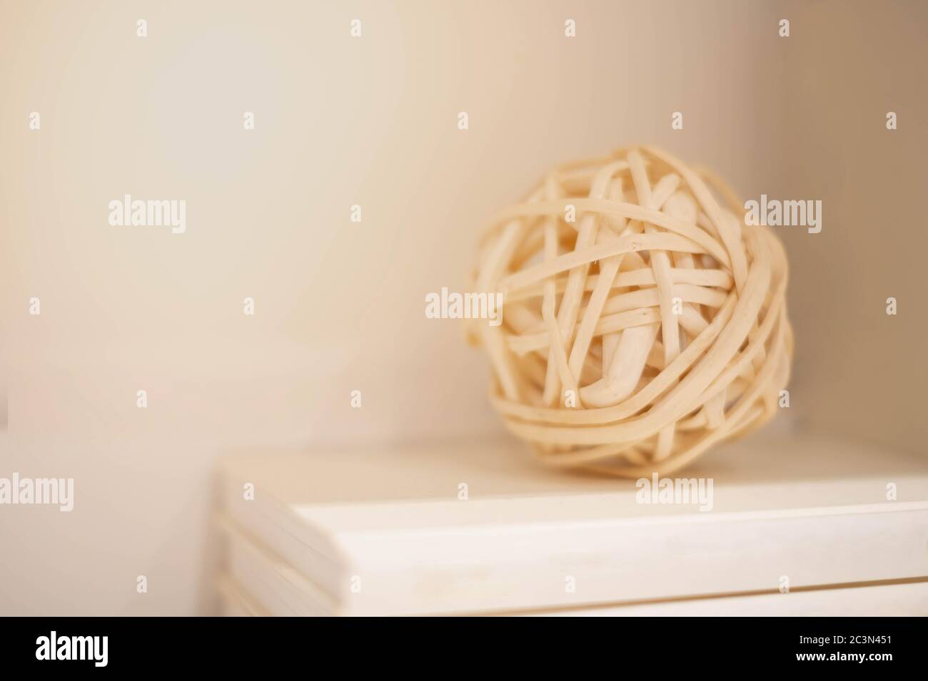 Le sfere marroni vimini da ramoscelli salici messo sul mucchio di libro, per sfondo o goccia posteriore, e decorare all'interno di una casa. Foto Stock