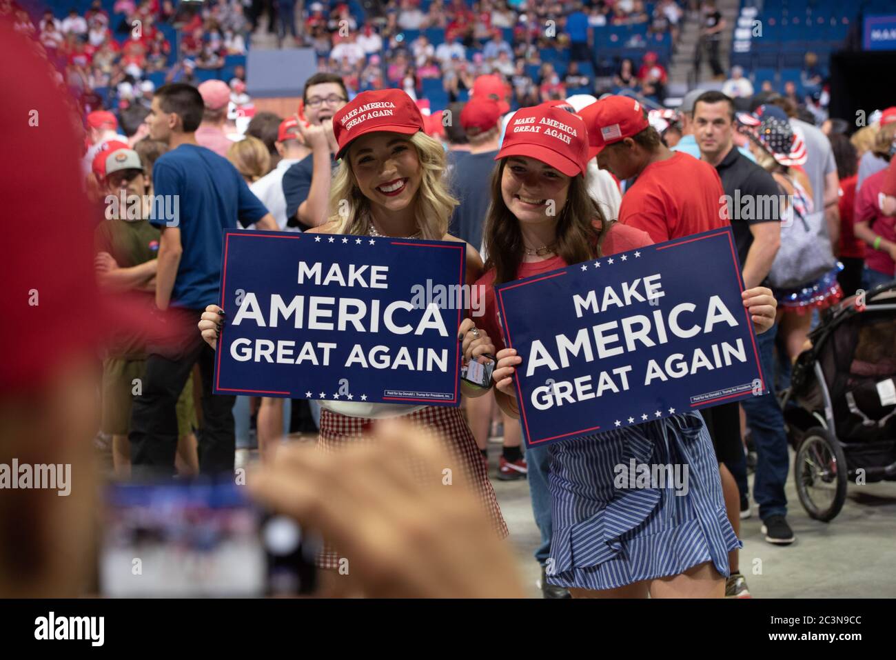 TULSA, Oklahoma, Stati Uniti. - 20 giugno 2020: Due donne sostenitrice di Trump che portano un segno come fotografo scatta la loro foto. Foto Stock