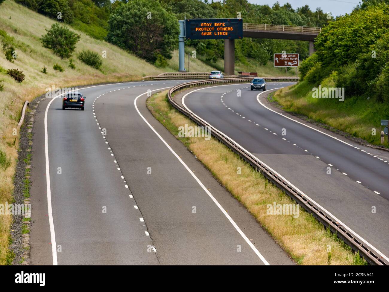 Traffico sulla A1 con il nuovo messaggio pandemico Covid-19 sul gantry 'Stay Safe Protect Others Save Lives', East Lothian, Scozia, Regno Unito Foto Stock