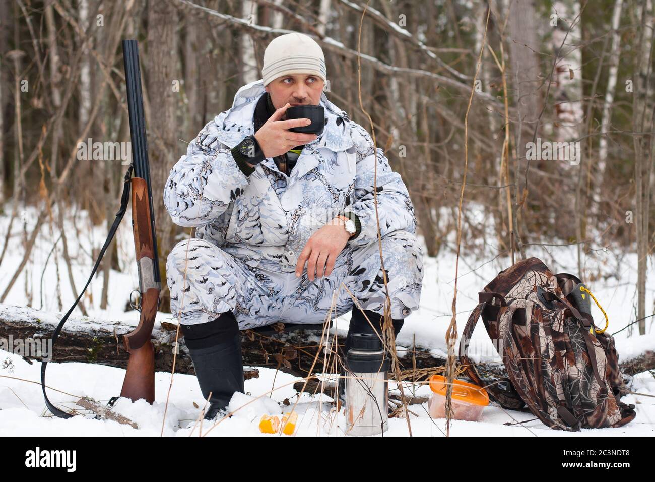 cacciatore in camuffamento durante il resto sulla caccia invernale Foto Stock