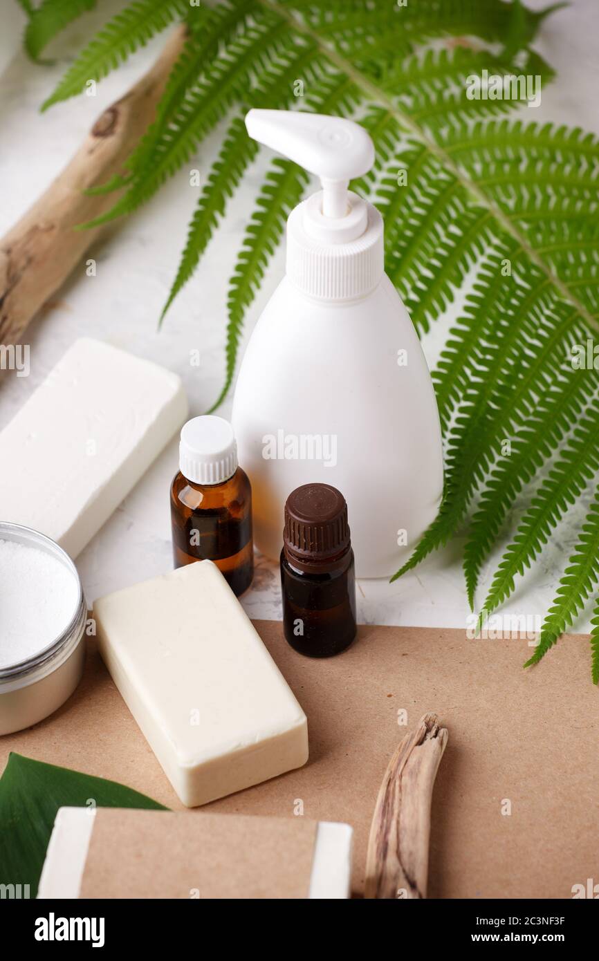 Accessori naturali per il bagno e cosmetici per la cura della pelle - sapone solido e shampoo, spazzolini da denti di bambù, oli essenziali, tema zero rifiuti su sfondo beige. Foto Stock