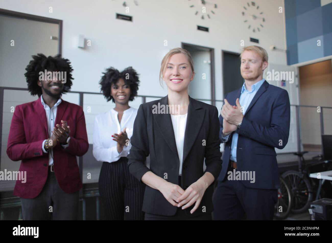 Leader di squadra femminile di successo in un abito formale che presenta il nuovo progetto per partner multietnici Foto Stock
