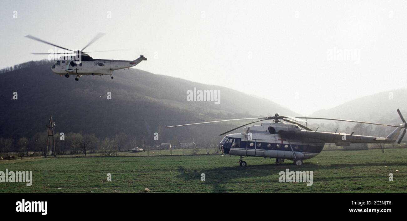 11 marzo 1994 durante la guerra in Bosnia: Vicino a Vitez, un elicottero Royal Navy Sea King HC4 decolli di fronte a un elicottero HVO (bosniaco croato) MIL mi-8MTV-1 HIP. Foto Stock