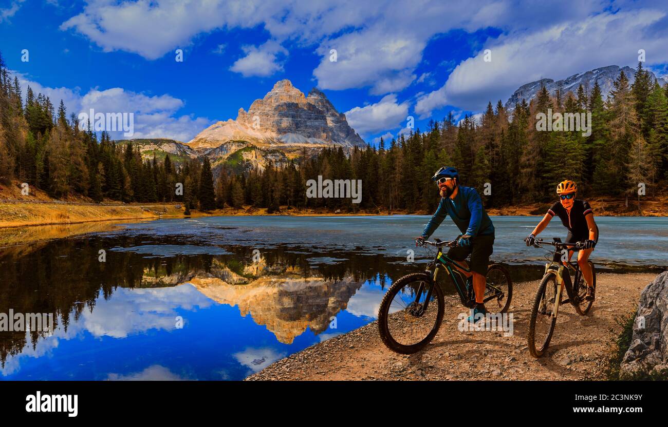 Ciclismo donna e uomo in bicicletta in Dolomiti montagna andscape. Coppia ciclabile MTB enduro pista. Attività sportive all'aperto. Foto Stock