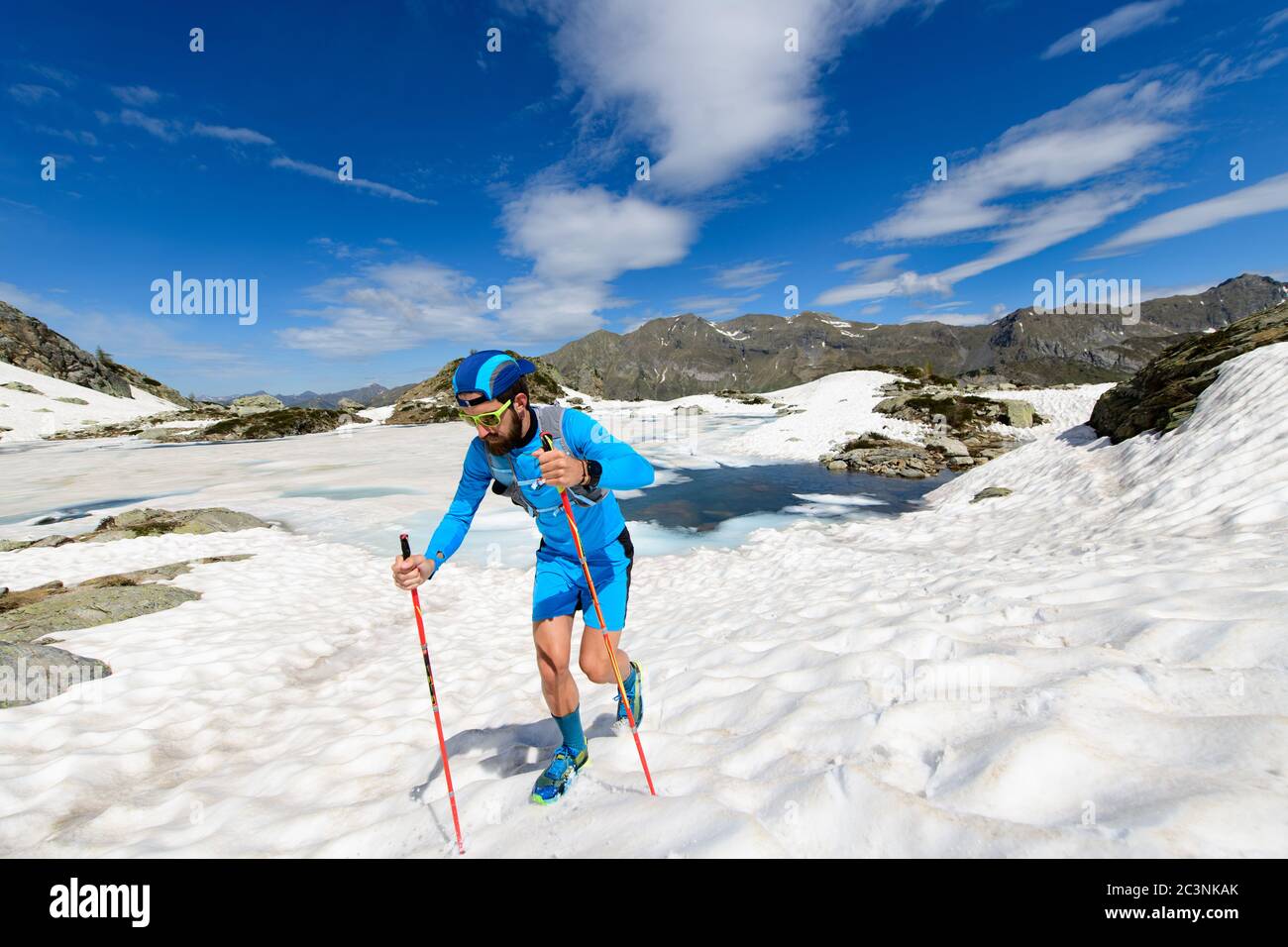Skyrunner uomo in azione in salita sulla neve Foto Stock