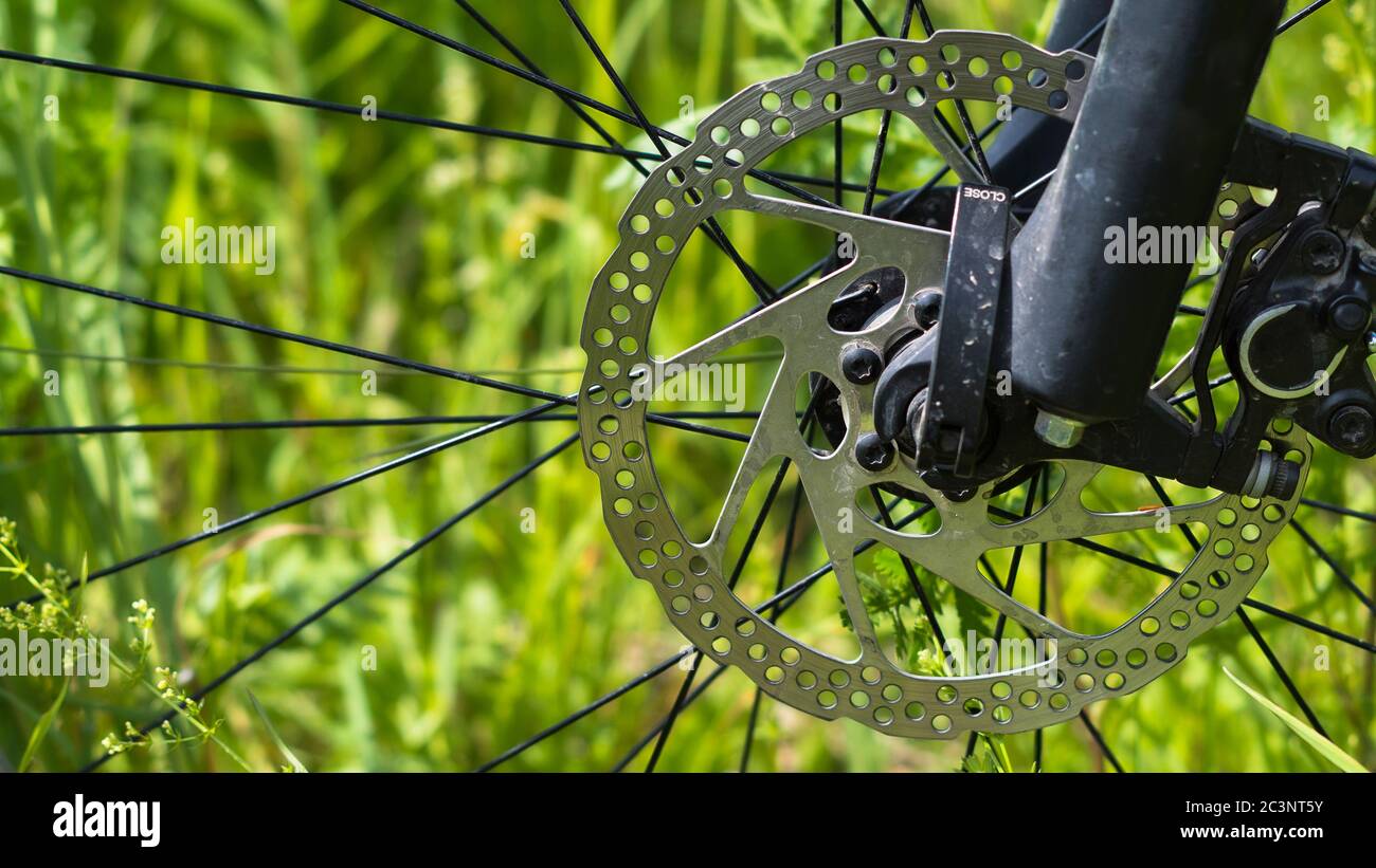 Disco del freno per bicicletta su fondo verde erba. Foto Stock