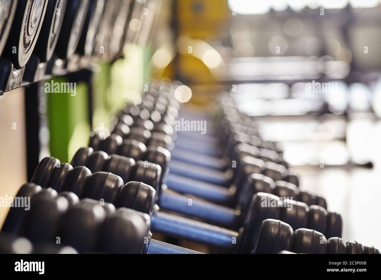 File di manubri in un club fitness sullo sfondo della palestra. Foto Stock