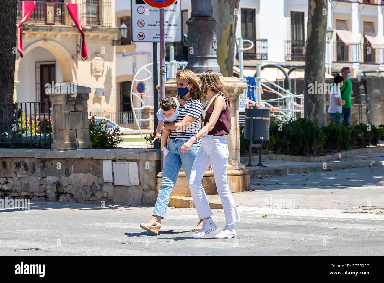 Baeza, Jaen, Spagna - 18 giugno 2020: Due donne che attraversano per passerella indossando maschere di protezione o medico durante lo stato di allarme e quarantena in Foto Stock