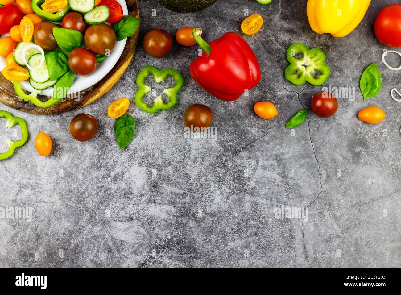 Ingredienti biologici freschi per la preparazione di insalate: Avocado, pomodori, basilico su sfondo rustico, vista dall'alto. Disposizione piatta con posizione per il testo. Vegano e sano f Foto Stock