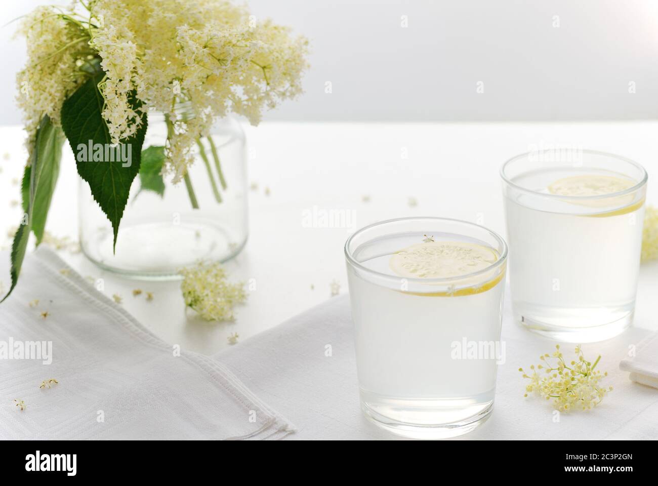 Bicchieri di limonata di fiori di sambuco con fette di limone su sfondo bianco. Medicina alternativa. Fiore, fuoco blossom. Selettivo, Foto Stock