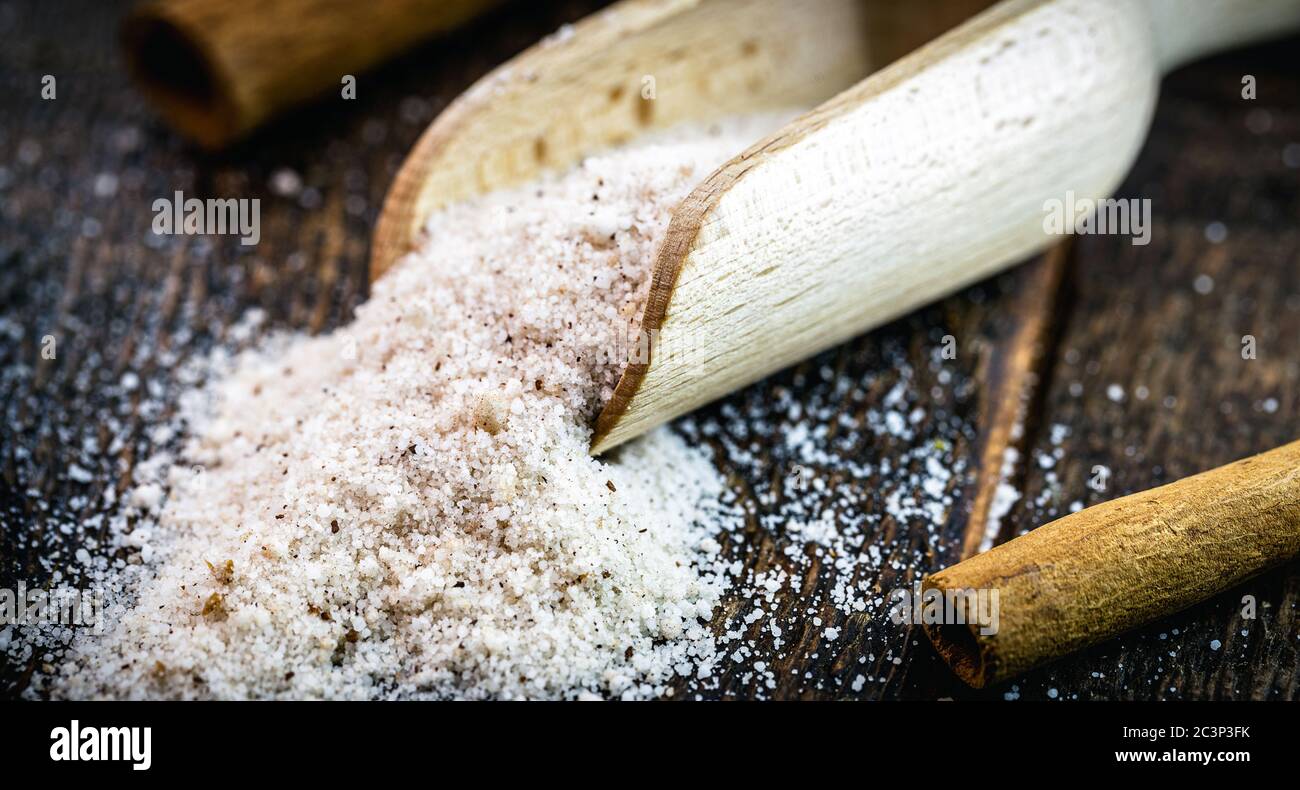 misurino in legno con cannella in polvere e zucchero raffinato, utilizzato come ingredienti per dolci e dessert. Foto Stock