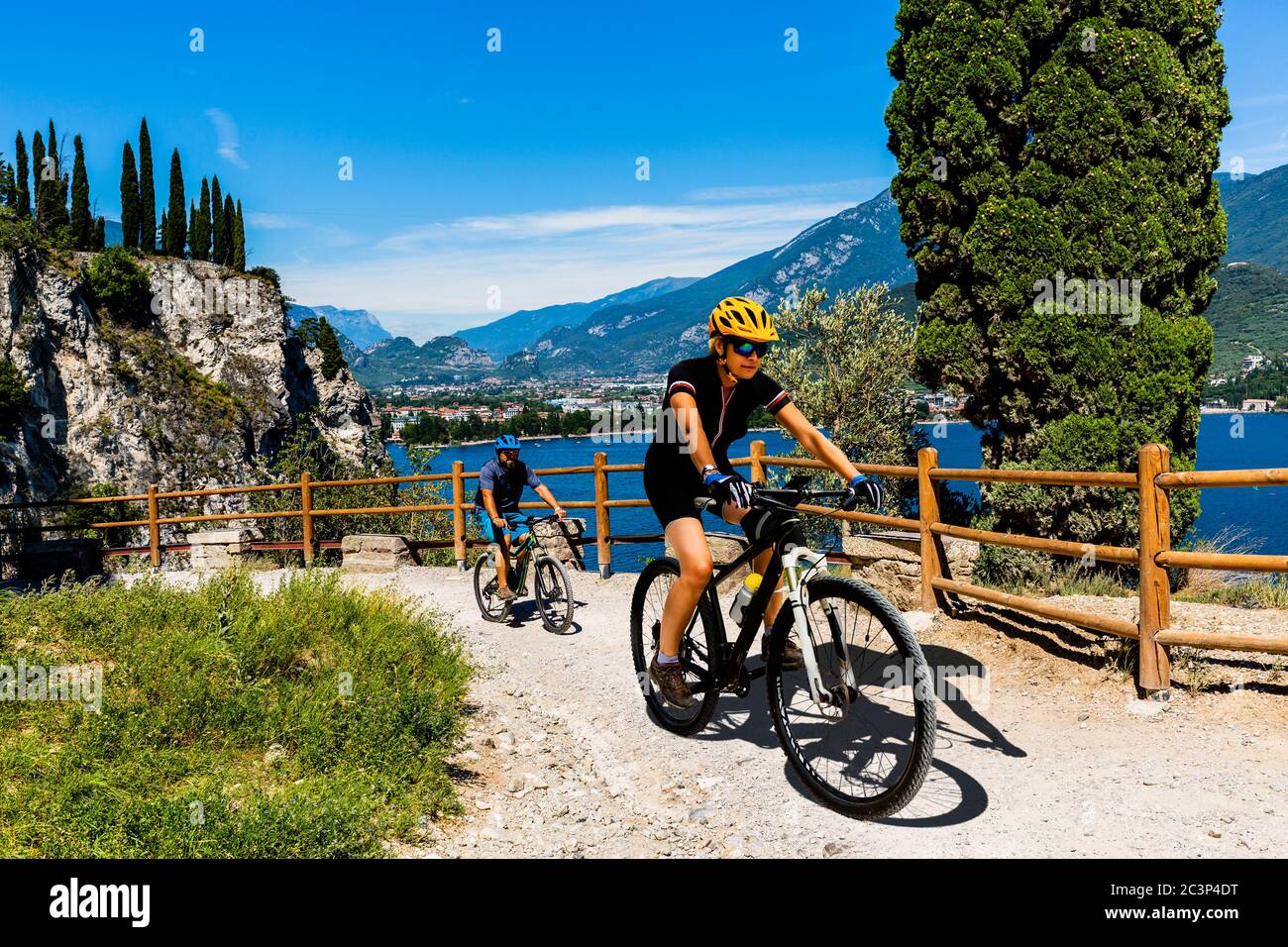 Ciclismo donna e uomo in bicicletta in montagna nel paesaggio del lago di Garda. Coppia ciclabile MTB enduro flusso sentiero ponale pista. Sport all'aperto Foto Stock