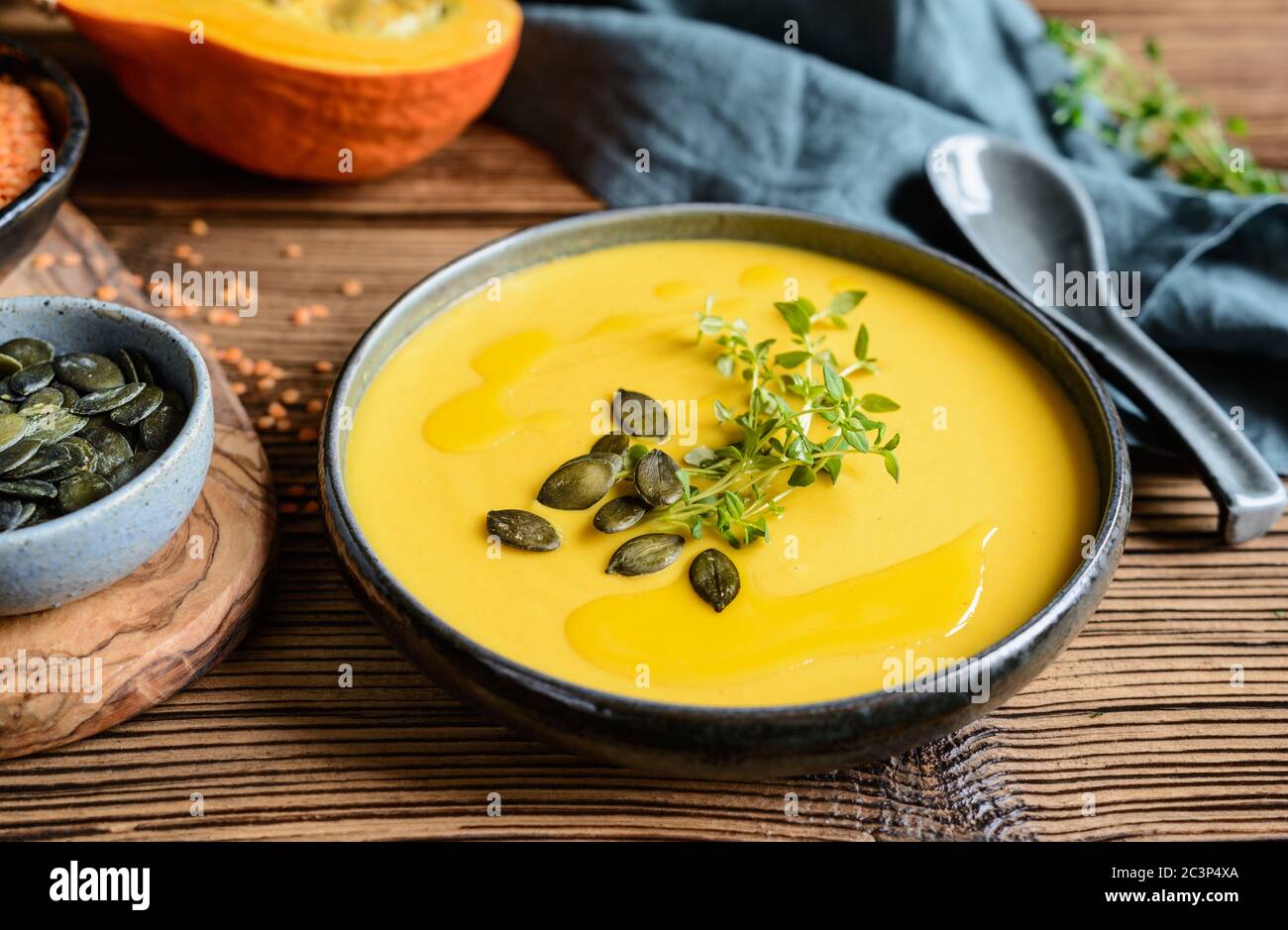 Piatto sano, deliziosa lenticchia rossa e crema vegana e zuppa di zucca ricoperta di timo fresco Foto Stock
