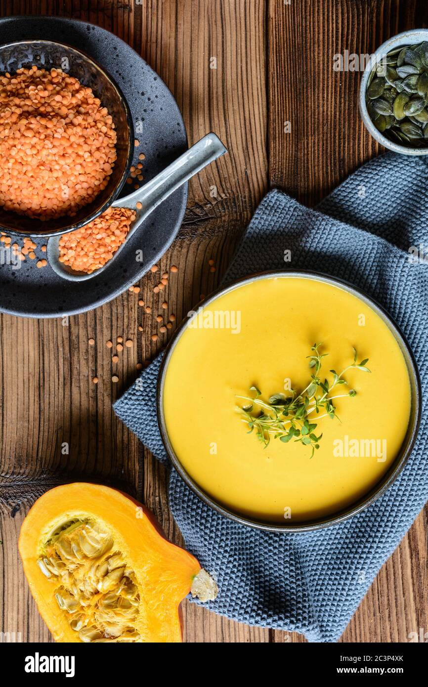 Piatto sano, deliziosa lenticchia rossa e crema vegana e zuppa di zucca ricoperta di timo fresco Foto Stock
