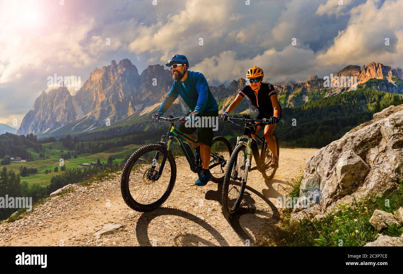 Ciclismo donna e uomo in bicicletta in Dolomiti montagna andscape. Coppia ciclabile MTB enduro pista. Attività sportive all'aperto. Foto Stock