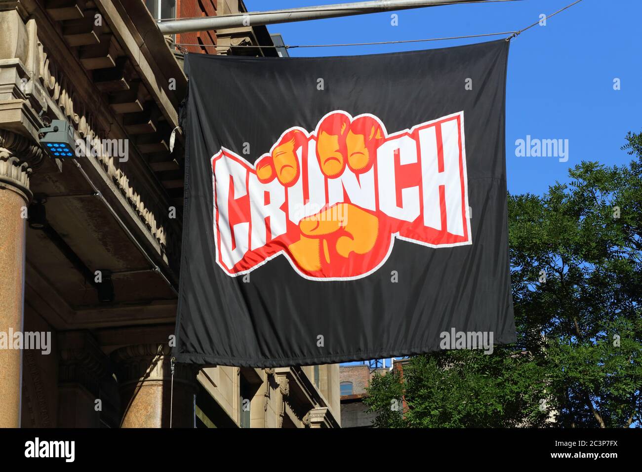 Una bandiera con il logo della palestra Crunch Fitness presso la loro sede di Chelsea a New York Foto Stock
