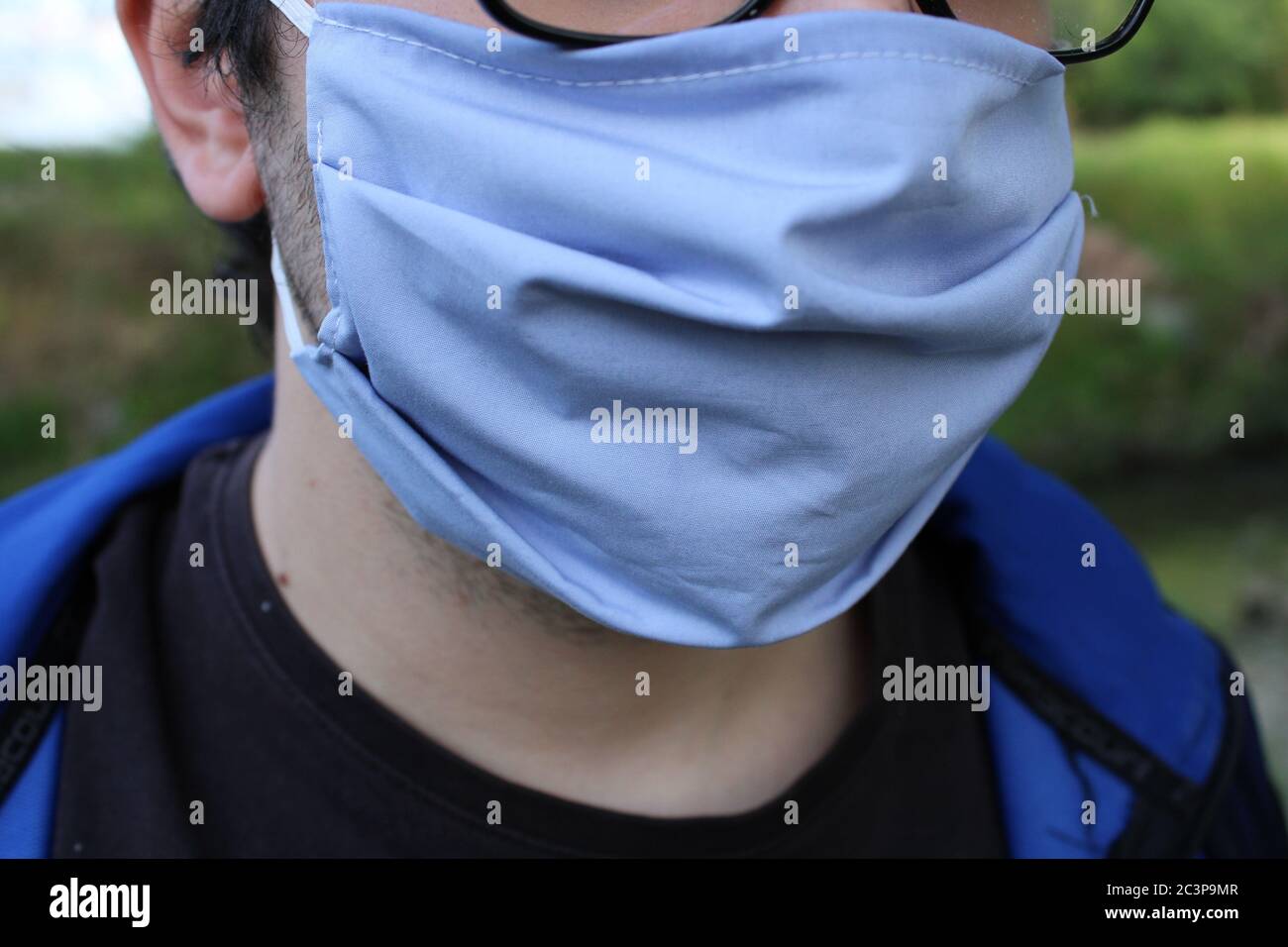 Vista di un maschio che indossa una maschera blu in un parcheggio Foto Stock