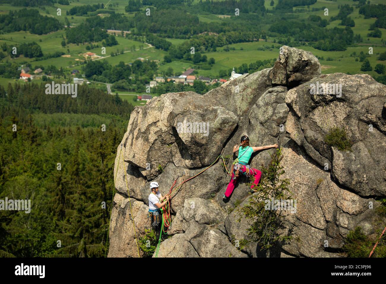 Donna che sale vicino alla cima con una vista spettacolare areale sui dintorni Foto Stock