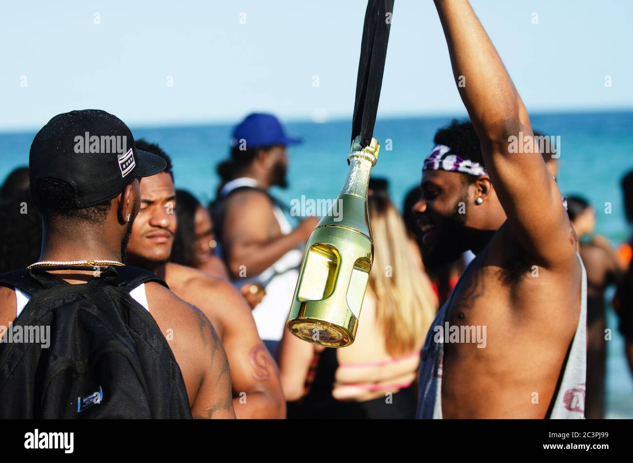 MIAMI - 16 MARZO 2019: Un giovane pangola una bottiglia d'oro di liquore ad un incontro di studenti universitari che celebrano la pausa primaverile a South Beach. Foto Stock
