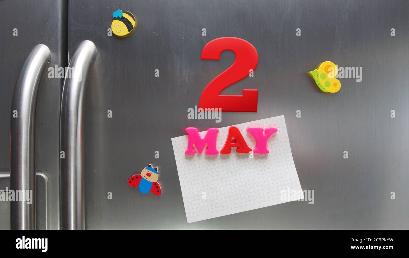 Data di calendario del 2 maggio fatta con lettere magnetiche di plastica che tengono una nota di carta grafica sul frigorifero della porta Foto Stock