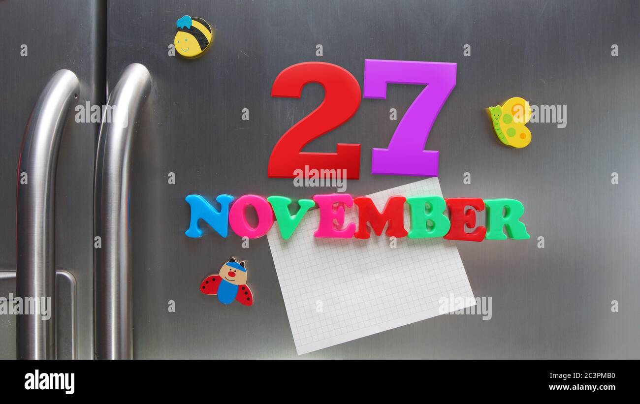 Novembre 27 data di calendario fatta con lettere magnetiche di plastica che tengono una nota di carta grafica sul frigorifero della porta Foto Stock