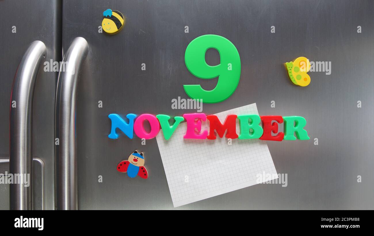Data di calendario del 9 novembre fatta con lettere magnetiche di plastica che tengono una nota di carta grafica sul frigorifero della porta Foto Stock
