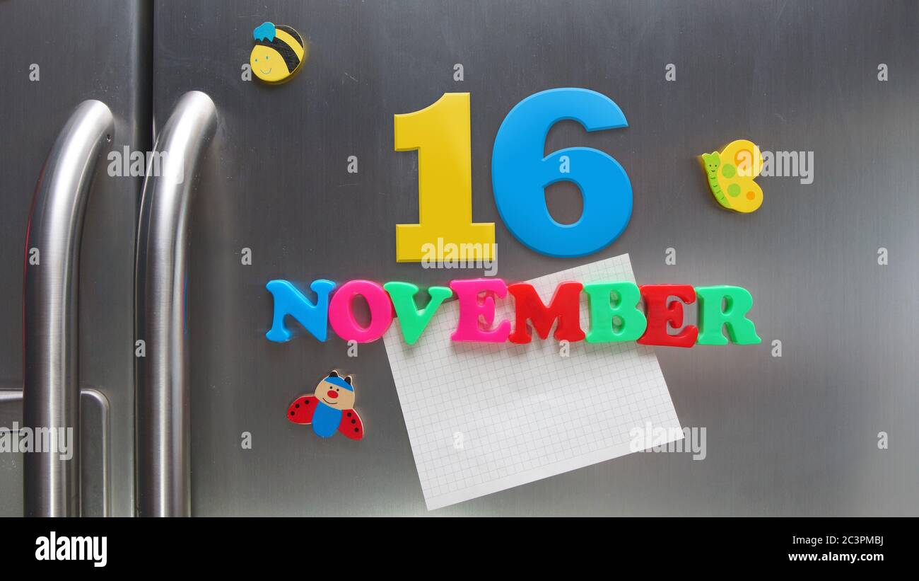 Novembre 16 data di calendario fatta con lettere magnetiche di plastica che tengono una nota di carta grafica sul frigorifero della porta Foto Stock