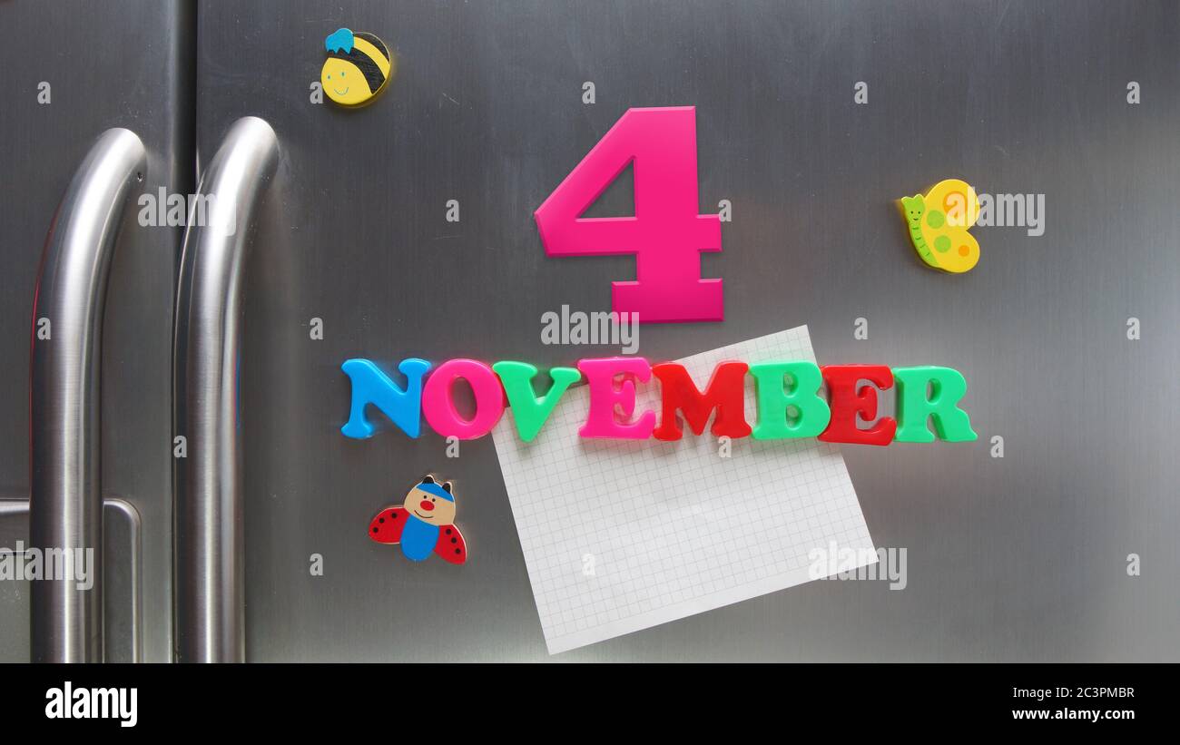 4 novembre data di calendario fatta con lettere magnetiche di plastica che tengono una nota di carta grafica sul frigorifero della porta Foto Stock