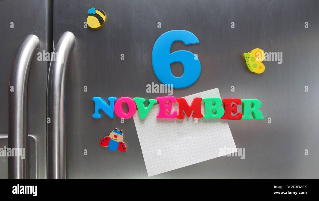 6 novembre data di calendario fatta con lettere magnetiche di plastica che tengono una nota di carta grafica sul frigorifero della porta Foto Stock