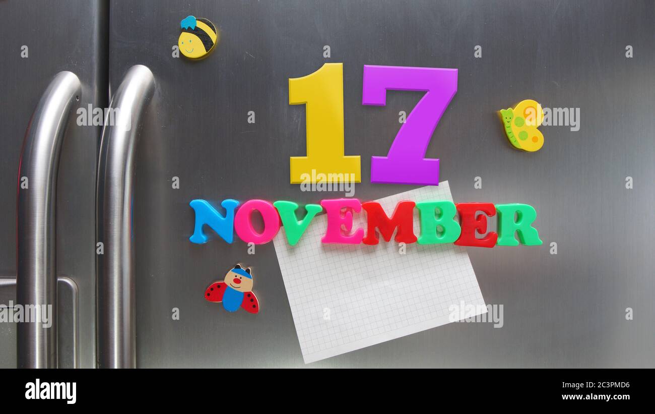 Novembre 17 data di calendario fatta con lettere magnetiche di plastica che tengono una nota di carta grafica sul frigorifero della porta Foto Stock