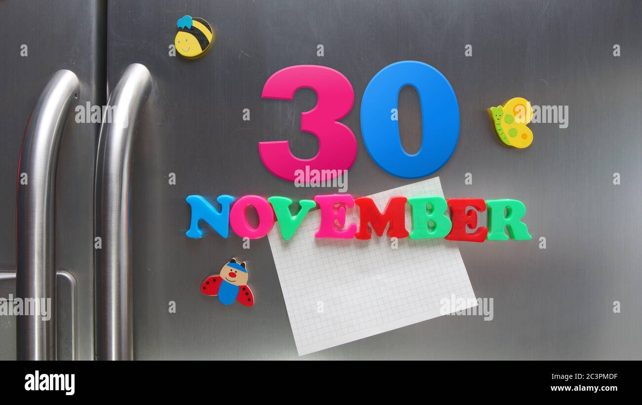 Novembre 30 data di calendario fatta con lettere magnetiche di plastica che tengono una nota di carta grafica sul frigorifero della porta Foto Stock