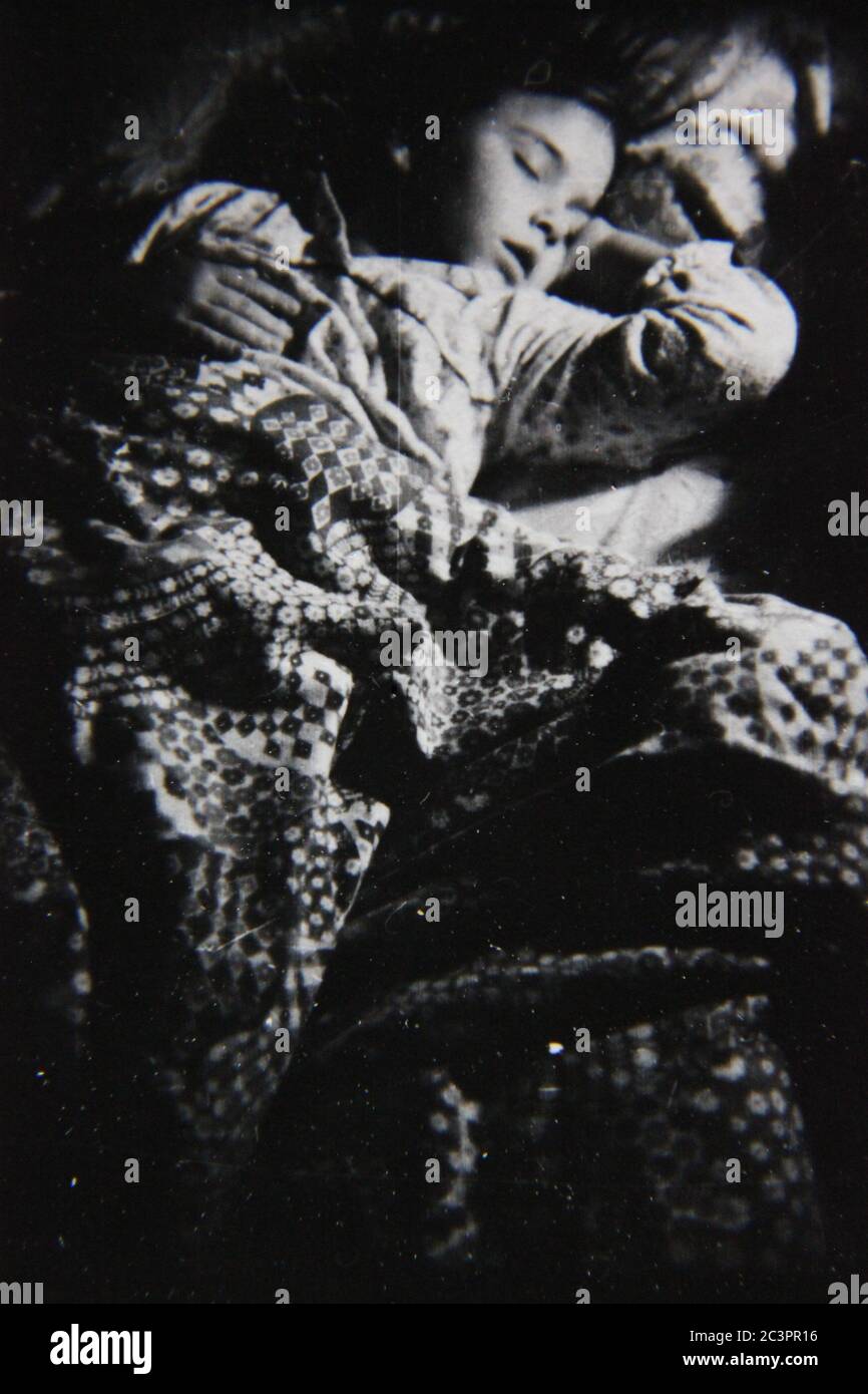 Fine anni 70 vintage in bianco e nero fotografia estrema di una ragazza di otto anni dormendo nel suo letto. Foto Stock