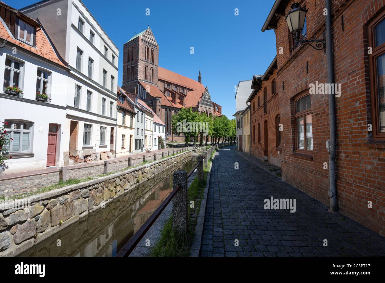 Chiesa di San Nicola (Nikolaikirche) e canale nel centro storico di Wismar contro un cielo blu, la città anseatica è una famosa destinazione turistica presso il Foto Stock