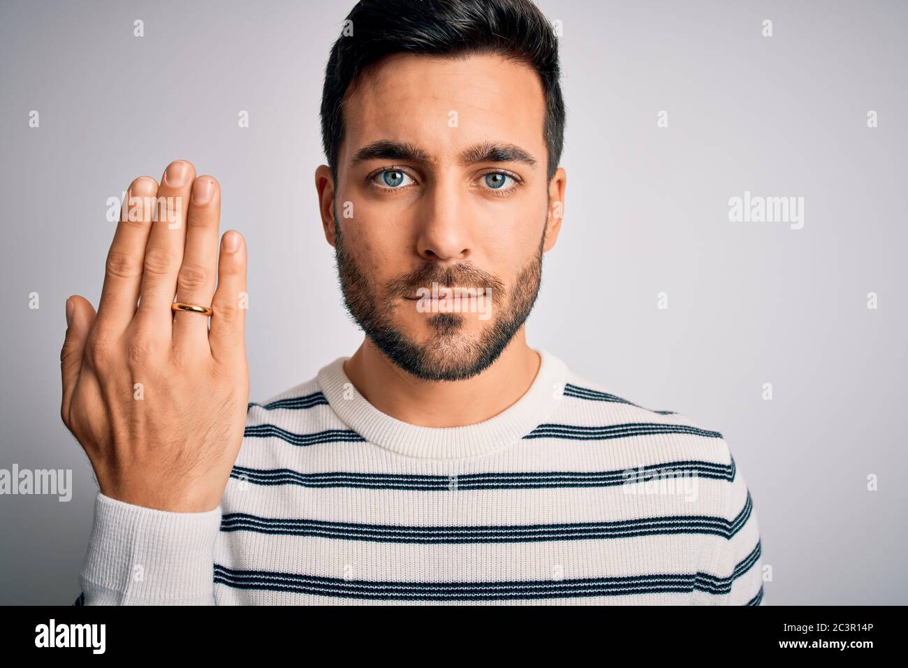 Bell'uomo con barba che mostra l'alleanza anello matrimonio sul dito su  sfondo bianco con un'espressione fiduciosa su smart face pensare serio Foto  stock - Alamy