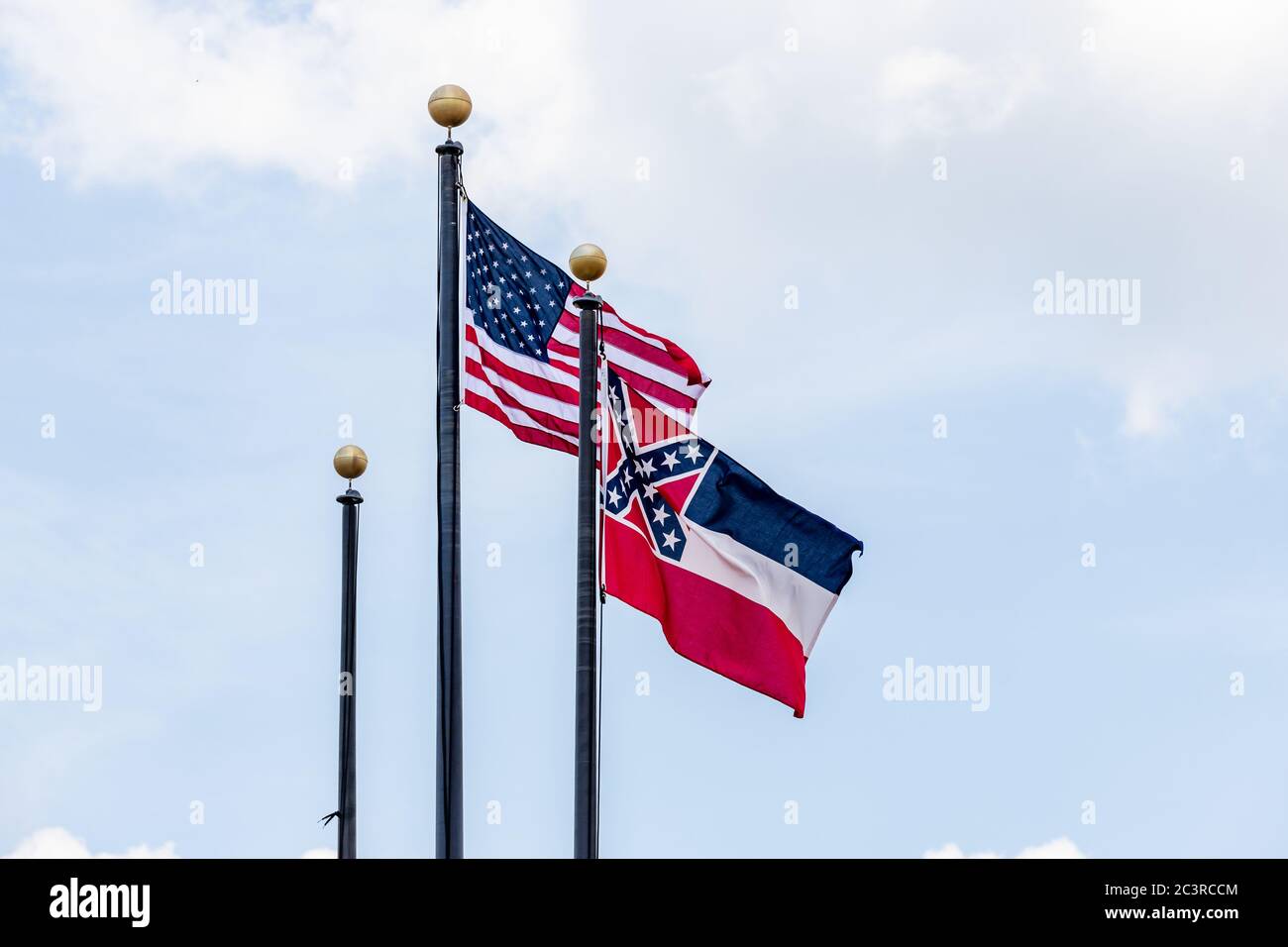 Pali di bandiera con bandiera degli Stati Uniti d'America e bandiera dello stato del Mississippi che sventolano nel vento contro il cielo blu. Foto Stock