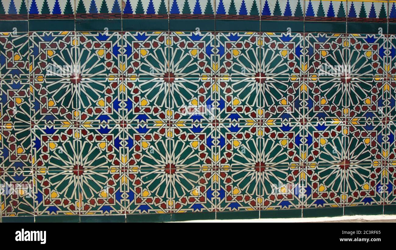 Particolare della parete decorata con ceramica verde, rossa, gialla e blu con disegno arabo floreale Foto Stock