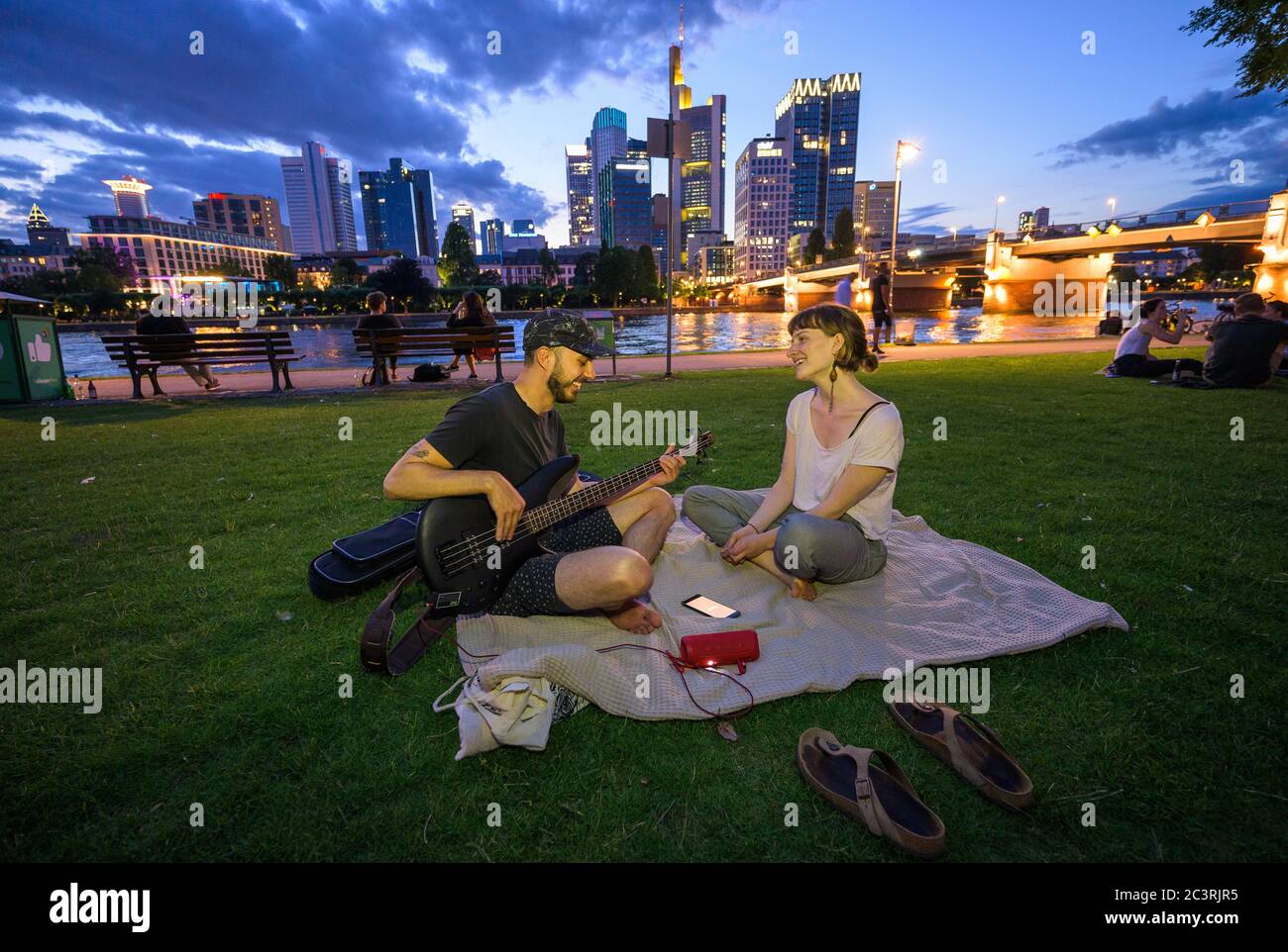 21 giugno 2020, Hessen, Francoforte sul meno: Marco e Sabika fanno musica e cantano insieme sulle rive del meno nella città bancaria. Marco sfrutta ogni opportunità per fuggire dall'ufficio di casa e ama recarsi sulla vicina riva del fiume meno. Sabika studia musica a Francoforte. Foto: Andreas Arnold/dpa Foto Stock