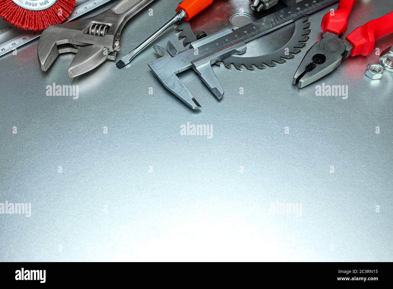 set di utensili professionali - chiave, pinza, calibro a corsoio e lama per sega circolare. fondo in metallo grigio Foto Stock