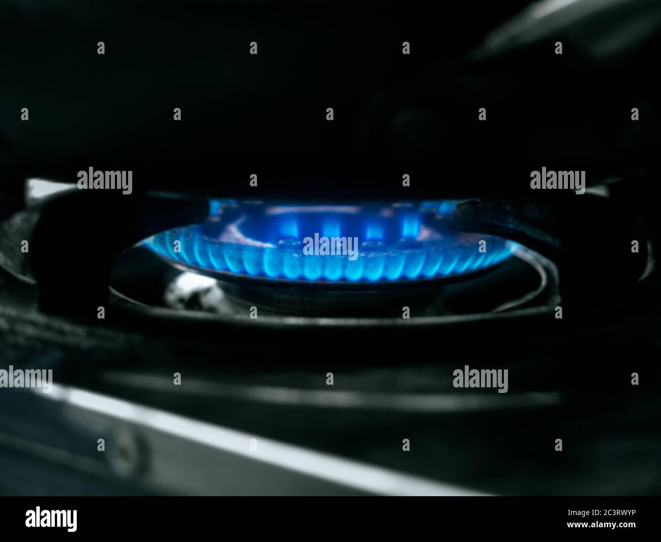 Sfondo sfocato di fiamma blu che brucia da cucina a gas fornello. Primo piano bruciatore a gas sfocato con fuoco blu. Foto Stock