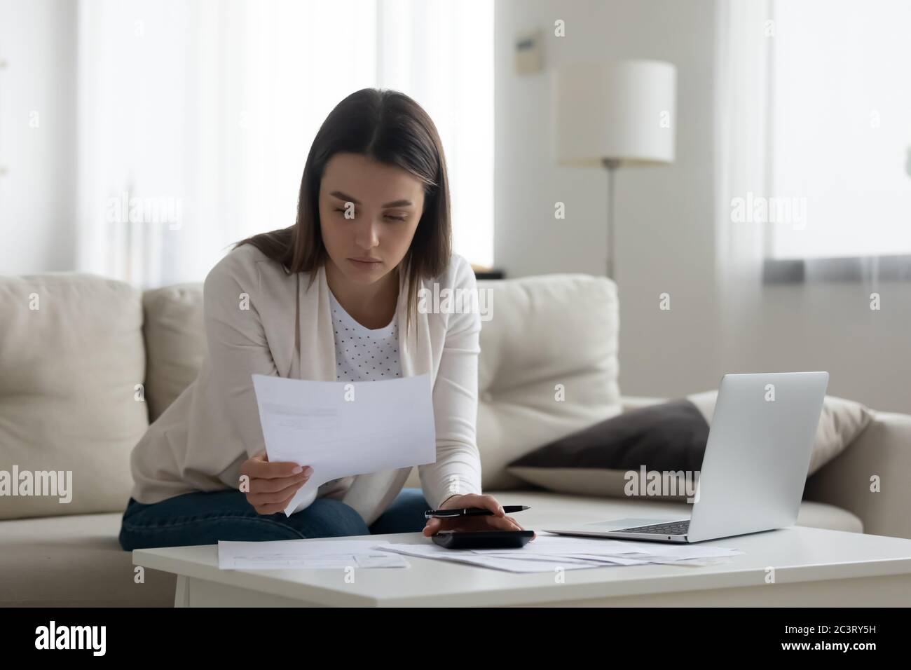 Il contabile che lavora con le fatture calcola le spese che lavorano a casa Foto Stock