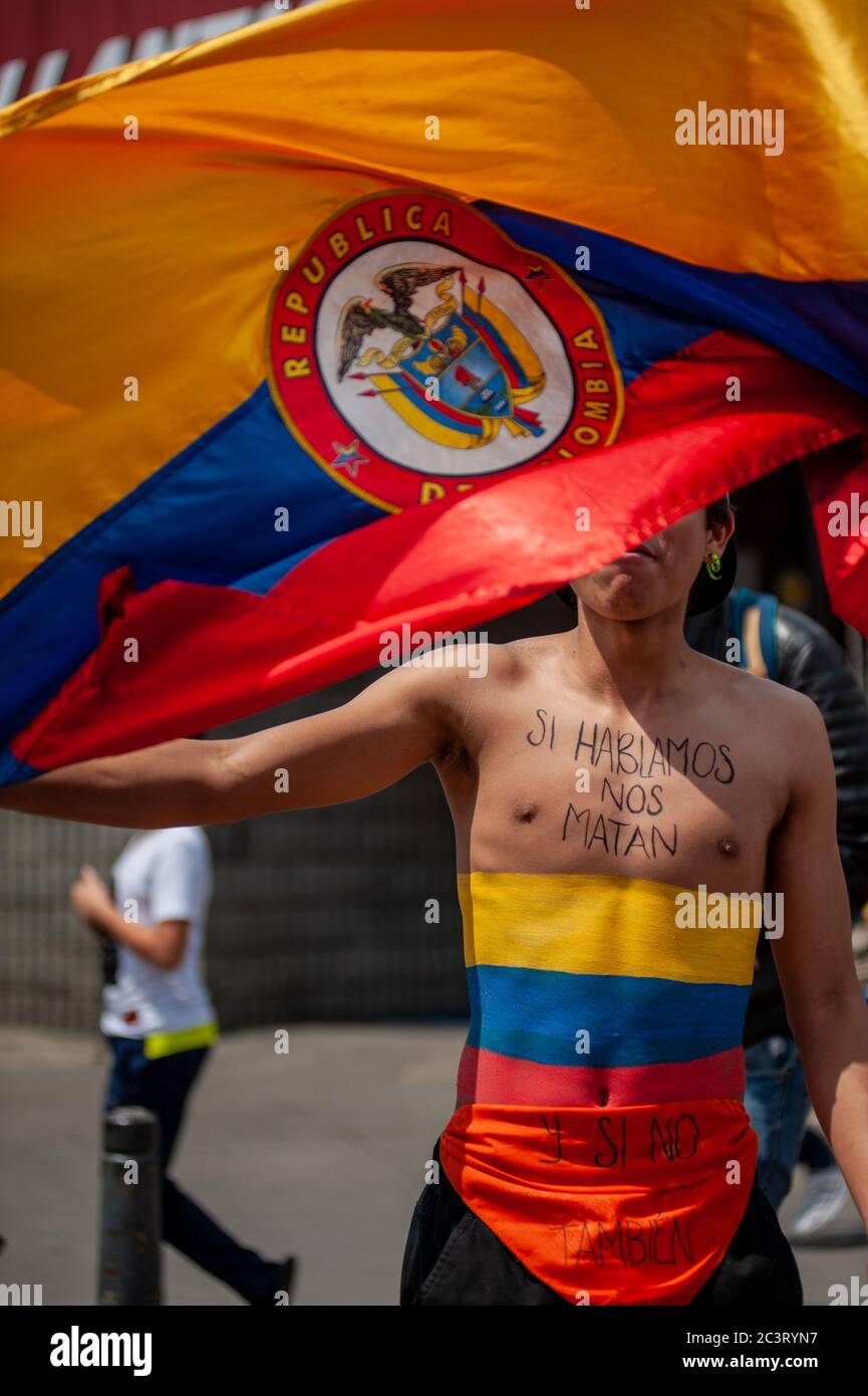 Lo studente ondeggia bandiera mentre ha scritto nel petto la bandiera colombiana dipinta e la frase 'se parliamo ci uccideranno, e se non lo faranno anche' Foto Stock