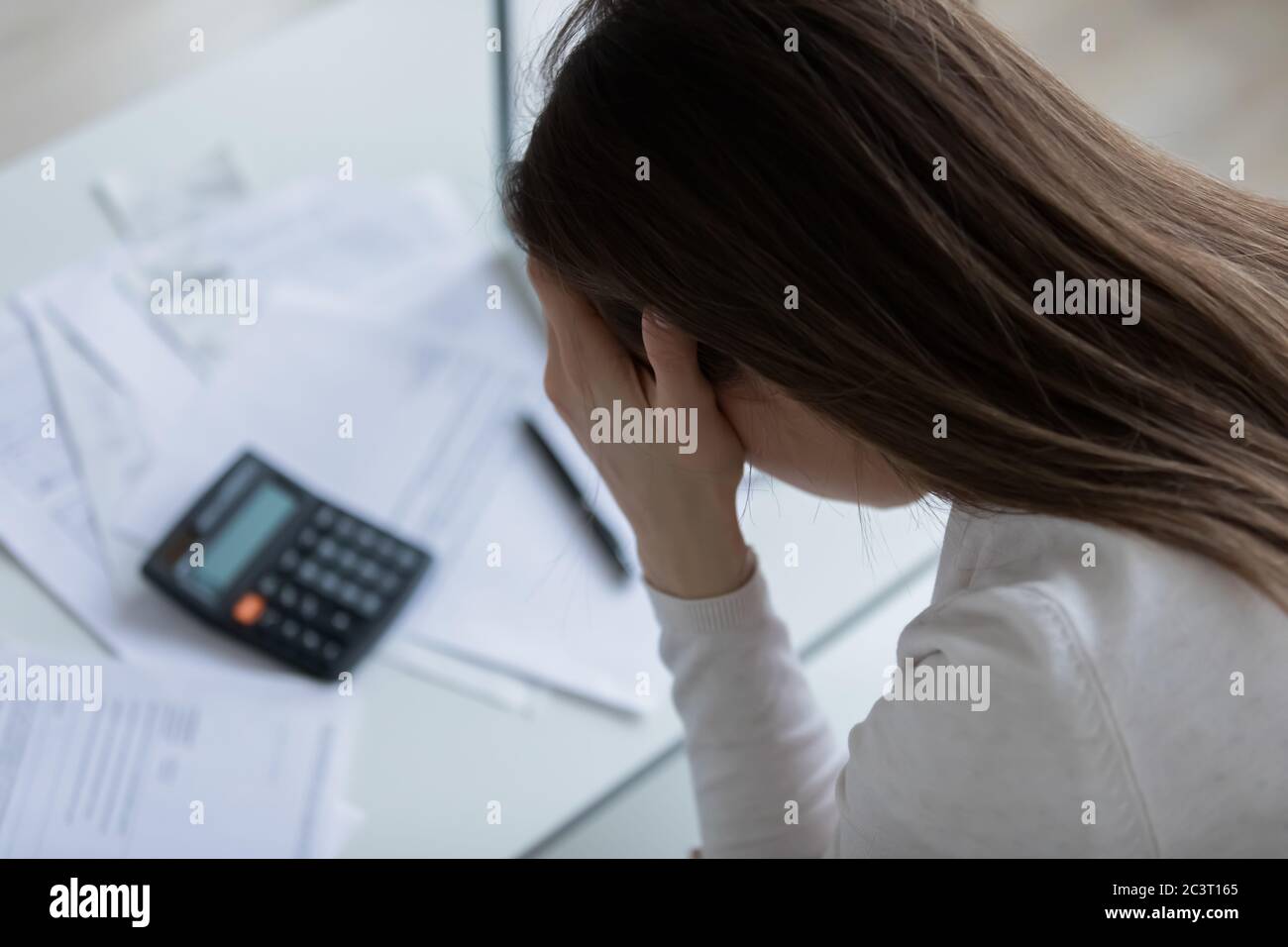 La donna si sente disperata dopo aver calcolato le spese avendo problemi finanziari Foto Stock