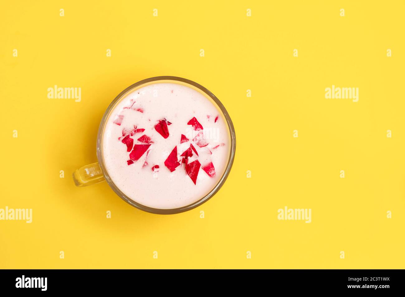 Latte ayurvedico rosa luna in una tazza di vetro su sfondo giallo con spazio per il testo Foto Stock