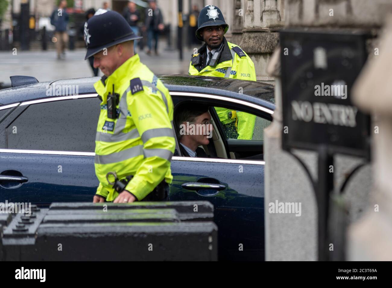 Jacob Rees Mogg guida nel Palazzo di Westminster con la sicurezza degli agenti di polizia. Ufficiale di polizia maschile nero. Un ufficiale ridendo. MP in auto Foto Stock