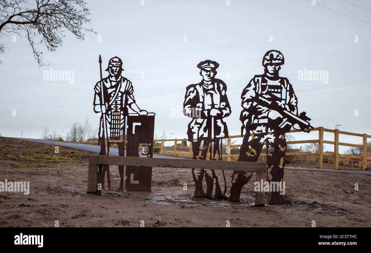 Sculture in metallo piatto di tre soldati di epoche diverse accanto a un sentiero a Catterick nel North Yorkshire Foto Stock